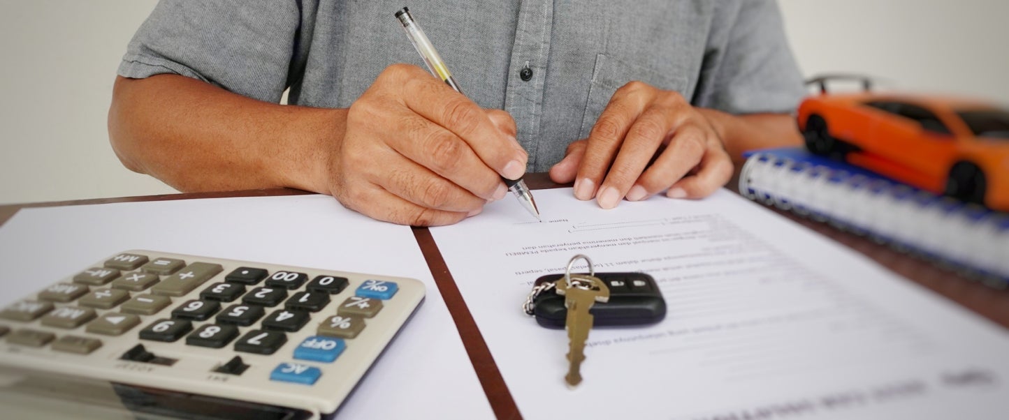 A man signing a contract on a lease agreement for a new car.