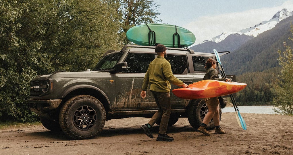 Ford Bronco vs Toyota 4runner 2026 Bronco® Badlands with available Ford Accessories. Couple carrying canoe