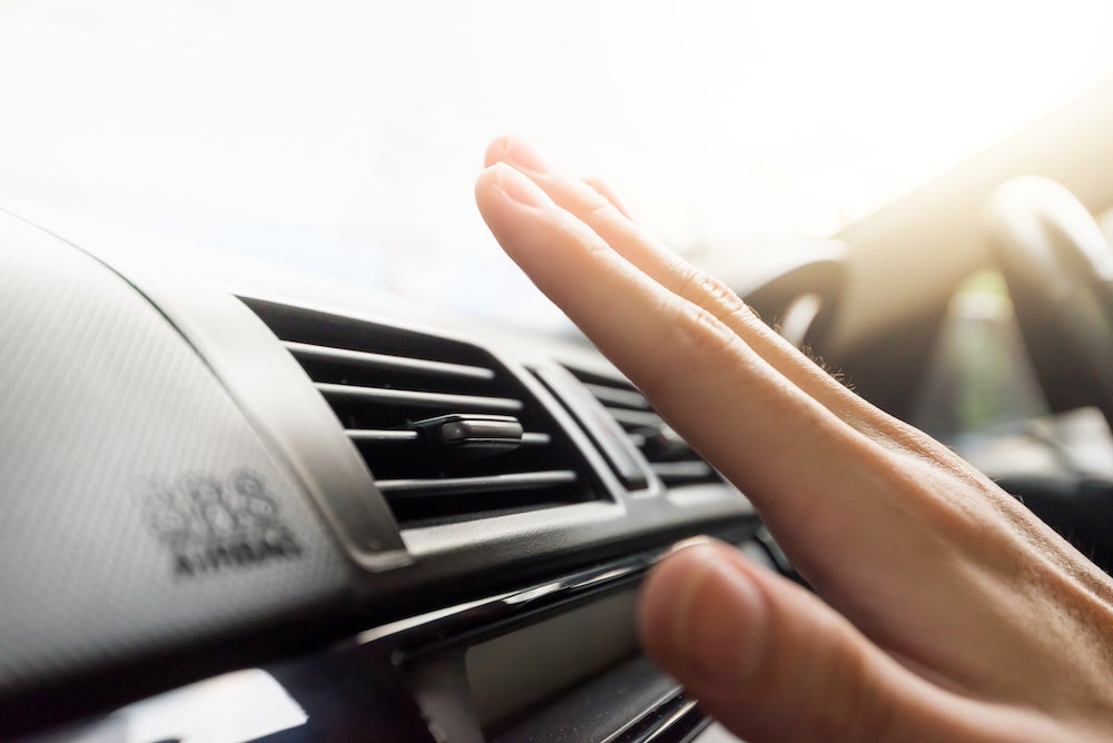 Why Isn't My AC Working? A hand feeling the air from a car's air conditioning vent